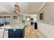 Well-lit kitchen with granite counters, an island with dark cabinets, plus stone-look floors, and modern pendant lights at 9363 Steubenville Ave, Englewood, FL 34224