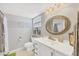 Clean bathroom with white vanity and large mirror at 944 Capri Isles Blvd # 201, Venice, FL 34292