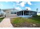 Brick pathway leading to a screened porch and grassy backyard at 9820 Royal Palm Dr, Bradenton, FL 34210