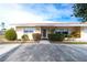 Tan house with a brown tile roof and a white front door at 9820 Royal Palm Dr, Bradenton, FL 34210