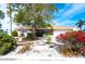 Landscaped front yard with trees and shrubs in front of a tan house at 9820 Royal Palm Dr, Bradenton, FL 34210