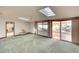 Spacious living room with skylights, carpet, and access to a patio at 9820 Royal Palm Dr, Bradenton, FL 34210