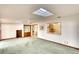 Living room with skylights, carpet, and kitchen passthrough at 9820 Royal Palm Dr, Bradenton, FL 34210