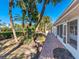Brick paved pathway alongside home, lush landscaping, and palm trees at 1221 S Basin Ln, Sarasota, FL 34242