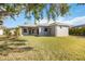 Exterior view of the home featuring a well-maintained lawn, covered porch, and mature trees at 12343 Lavender Loop, Bradenton, FL 34212