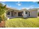 Expansive backyard featuring well-maintained grass, a covered patio, and stylish stone paver accents at 12343 Lavender Loop, Bradenton, FL 34212