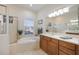 This bathroom features a soaking tub, glass shower, and double sink vanity with neutral tile at 12343 Lavender Loop, Bradenton, FL 34212