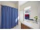 Bright bathroom featuring a shower with blue striped curtain, and vanity with white countertop at 12343 Lavender Loop, Bradenton, FL 34212