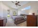Serene bedroom with a ceiling fan, a large window, and a door to the outdoors at 12343 Lavender Loop, Bradenton, FL 34212