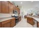 Open kitchen with stainless steel appliances, wood cabinets, and a view into the living room at 12343 Lavender Loop, Bradenton, FL 34212