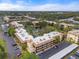 Aerial view of a condo community with a central pond, surrounded by lush greenery and parking at 305 30Th W Ave # A208, Bradenton, FL 34205