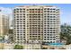 Luxury high-rise building with a pool and lush landscaping at 35 Watergate Dr # 801, Sarasota, FL 34236