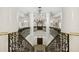 Elegant grand staircase with ornate railing and crystal chandelier at 35 Watergate Dr # 801, Sarasota, FL 34236
