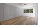 Bright bedroom with wood floors, gray board and batten wall, and sliding glass door at 3791 Surrey Ln, Sarasota, FL 34235