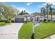 White house with gray accents, attached garage, and manicured lawn at 3791 Surrey Ln, Sarasota, FL 34235