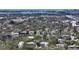 Aerial view showcasing a charming home surrounded by mature trees with water in the distance at 3930 Elysian Woods Ln, Sarasota, FL 34231
