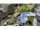 Aerial view of home with screened pool, lush landscaping, and waterfront access at 3930 Elysian Woods Ln, Sarasota, FL 34231