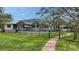 Beautiful backyard featuring a screened-in pool, manicured lawn, and privacy fencing at 3930 Elysian Woods Ln, Sarasota, FL 34231