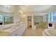 Well-appointed bathroom with dual sinks, a walk-in shower, and a soaking tub at 3930 Elysian Woods Ln, Sarasota, FL 34231