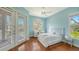 Relaxing light blue bedroom with wood floors, lots of natural light and a small desk at 3930 Elysian Woods Ln, Sarasota, FL 34231