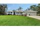Home featuring metal roof, lush lawn, and mature landscaping at 3930 Elysian Woods Ln, Sarasota, FL 34231