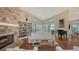 Inviting living room with a stone fireplace, built-in bookshelves, piano and large windows at 3930 Elysian Woods Ln, Sarasota, FL 34231