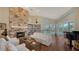 Comfortable living room features a stone fireplace, built-in bookcase, and view to backyard pool area at 3930 Elysian Woods Ln, Sarasota, FL 34231