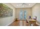 Bright office space with French doors to the outdoor patio and an oversized nature painting at 3930 Elysian Woods Ln, Sarasota, FL 34231