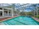 Large, screened swimming pool with spa, surrounded by a wooden deck, garden, and access to the outdoor patio at 3930 Elysian Woods Ln, Sarasota, FL 34231
