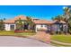 Luxury home with tile roof, palm trees, and a paved driveway at 504 Mast Dr, Bradenton, FL 34208