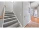 Modern staircase with gray carpeting and wood railing at 504 Mast Dr, Bradenton, FL 34208