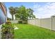 Spacious, enclosed backyard with a lush lawn, mature trees, and a white privacy fence, providing a serene retreat at 5111 26Th St. Ct, W # 53, Bradenton, FL 34207