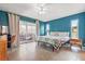 Bright bedroom featuring stylish decor, tiled floor, blue accent wall, and sliding glass door to balcony at 5111 26Th St. Ct, W # 53, Bradenton, FL 34207