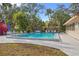 Inviting community pool surrounded by lounge chairs, mature trees, and lush landscaping for relaxing outdoor enjoyment at 5111 26Th St. Ct, W # 53, Bradenton, FL 34207