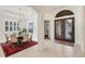 Elegant dining room with a large table, chandelier, and red rug at 7443 Riviera Cv, Lakewood Ranch, FL 34202