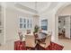 Elegant dining room featuring a round table, chandelier, and area rug at 7443 Riviera Cv, Lakewood Ranch, FL 34202