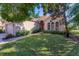 Tan house with lush landscaping and a walkway to the entrance at 7443 Riviera Cv, Lakewood Ranch, FL 34202