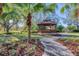 A charming gazebo with a brick pathway is nestled among lush landscaping at 7443 Riviera Cv, Lakewood Ranch, FL 34202