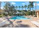 Inviting community pool with ample lounge chairs and surrounding palm trees at 7786 Moonstone Dr # 7-204, Sarasota, FL 34233