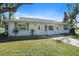 Front view of a charming light-colored home with a spacious yard at 1005 Hines Ave, Sarasota, FL 34237