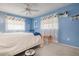 Blue bedroom with white bed, ceiling fan, and decorative shelf at 1121 Danny Dr, Sarasota, FL 34243