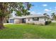 Charming single-story home with a blue garage door, stone accents, and a large front yard at 1121 Danny Dr, Sarasota, FL 34243