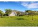 Expansive backyard with well-manicured lawn, mature trees, and a view of the home's exterior and screened-in patio at 13789 Old Creek Ct, Parrish, FL 34219