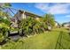 Beautiful backyard featuring tropical landscaping, a screened-in patio, and a well-maintained lawn at 13789 Old Creek Ct, Parrish, FL 34219