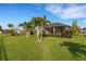 Lush backyard featuring a screened-in patio, vibrant landscaping, palm trees, and a well-maintained lawn at 13789 Old Creek Ct, Parrish, FL 34219