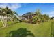 Lush backyard featuring tropical landscaping, a screened-in patio, and a well-maintained lawn at 13789 Old Creek Ct, Parrish, FL 34219