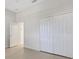 Bright bedroom features tile flooring, neutral paint, and a closet with double doors at 13789 Old Creek Ct, Parrish, FL 34219