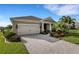 Beautiful home with a two-car garage, a paver driveway, and lush landscaping at 13789 Old Creek Ct, Parrish, FL 34219