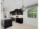 Beautiful kitchen with dark cabinetry, granite countertops, stainless steel appliances, and modern lighting fixtures at 13789 Old Creek Ct, Parrish, FL 34219