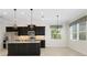 A well-lit kitchen featuring stainless steel appliances, granite countertops, a kitchen island, and decorative pendant lighting at 13789 Old Creek Ct, Parrish, FL 34219